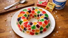 Pudim de gelatina mosaico: cubos coloridos e creme de iogurte bem fresco